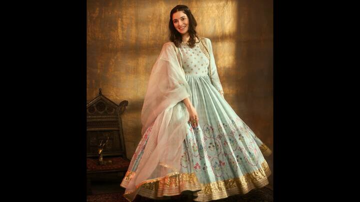 7. ⁠Pastel Royalty In Dreamy Anarkali: Divya Khosla Kumar brings pure grace to the frame in this breathtaking pastel Anarkali. The highlight of this ensemble is its soothing powder-blue palette, adorned with intricate floral embroidery that feels straight out of a vintage painting. The bodice features subtle golden motifs, adding just the right touch of shimmer without overwhelming the pastel base. Paired with a sheer, ethereal dupatta that falls beautifully around her shoulders, the look exudes effortless elegance. Divya keeps her accessories refined with antique-finish jewellery that complements the soft colour story. The statement ring and delicate earrings add a regal finish while allowing the artistry of the outfit to remain the hero. (Image Source: Instagram/@divyakhossla)