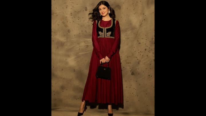 8. ⁠Deep-Red Anarkali Look: Divya Khosla Kumar serves pure old-world elegance in this striking deep-red Anarkali. This look blends vintage charm with modern minimalism, making it a standout for winter weddings, cultural events, and festivities. The highlight of this ensemble is the rich, jewel-toned Anarkali that flows beautifully, creating a long, fluid silhouette. The outfit gains an elevated, regal touch with a cropped black velvet jacket embellished with intricate gold embroidery. This layering instantly adds structure and depth. Divya completes the look with statement earrings, a bold ring, and a chic black mini handbag that ties the entire palette together. (Image Source: Instagram/@divyakhossla)