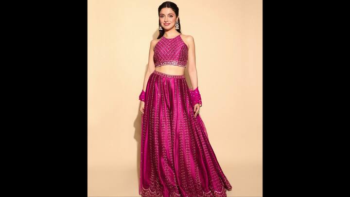 4. ⁠Hot Pink Mirror Work Lehenga: Divya Khosla Kumar brings full festive glamour with this stunning hot pink mirror-work lehenga. The ensemble features a vibrant fuchsia lehenga skirt adorned with intricate mirror embellishments, forming rhythmic vertical patterns that elongate the silhouette and add a mesmerising sparkle with every movement. The scalloped hemline gives the piece a delicate feminine finish, making it both regal and playful. The matching sleeveless, high-neck blouse is equally dazzling, covered in geometric mirror detailing that adds structure and a contemporary twist. (Image Source: Instagram/@divyakhossla)