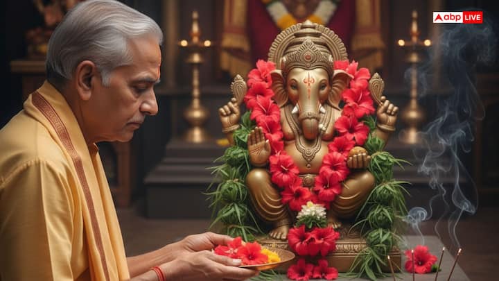 21 गांठें और फूल अर्पित करें. दूर्वा अर्पित करते समय 'इदं दुर्वादलं ओम गं गणपतये नमः' और फूल अर्पित करते समय 'एष: पुष्पान्जलि ऊं गं गणपतये नमः' मंत्र बोलें. अगरबत्ती और घी का दीपक जलाएं, उसके बाद मोदक, लड्डू मिठाई का भोग लगाएं. भोग के बाद ' इदं ताम्बूल पुगीफल समायुक्तं ऊं गं गणपतये समर्पयामि:' बोलकर पान और सुपारी भी चढ़ाएं.