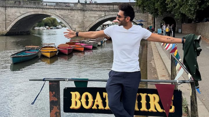 Kartik keeps it classic with this crisp white T-shirt paired with relaxed navy trousers and clean white sneakers. Sunglasses and a jacket casually in hand add a polished yet laid-back edge to the riverside-ready look. (Image Source: Instagram/ kartikaaryan)