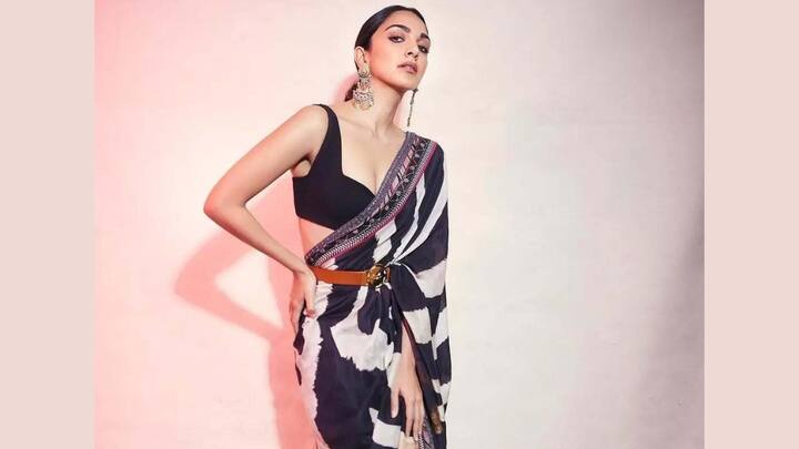 Kiara Advani’s black-and-white striped saree with earthy tones makes a bold statement at festive events. The modern abstract stripes paired with a sharp blouse and waist belt offer a stylish fusion of classic draping and high-fashion structure. (Image Source: Instagram/ pinkvillalifestyle)