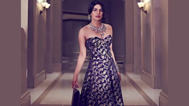 Royal Navy Brocade: She channels old-world royalty in this deep-navy silk brocade lehenga adorned with detailed gold floral motifs. The strapless corset-style blouse brings a modern edge, complemented by the richly bordered skirt and matching dupatta. Her diamond-and-pearl jewels and classic low bun seal the ensemble with regal sophistication. (Image Source: Instagram/ stylebyami)
