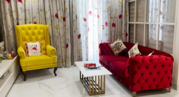 लिविंग एरिया में एक ब्रिक पैटर्न वाली वॉल है, जो कमरे को स्टाइलिश और थोड़ा अलग लुक देती है. यहां रखा बड़ा रेड सोफा और ब्राइट येलो आर्मचेयर बैठने के लिए काफी आरामदायक हैं. ये जगह देखने में भी खूबसूरत लगती है और आराम करने के लिए एकदम परफेक्ट कॉर्नर बन जाती है.