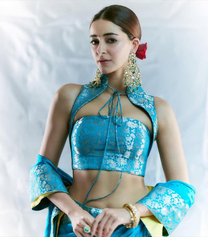 From jewellery, make-up and hairstyle are also absolutely perfect. She completed her look with long golden Chand Bali earrings. These earrings have green emerald and pearl detailing which further enhances the beauty of these earrings. She completed her look by applying roses to her hair.