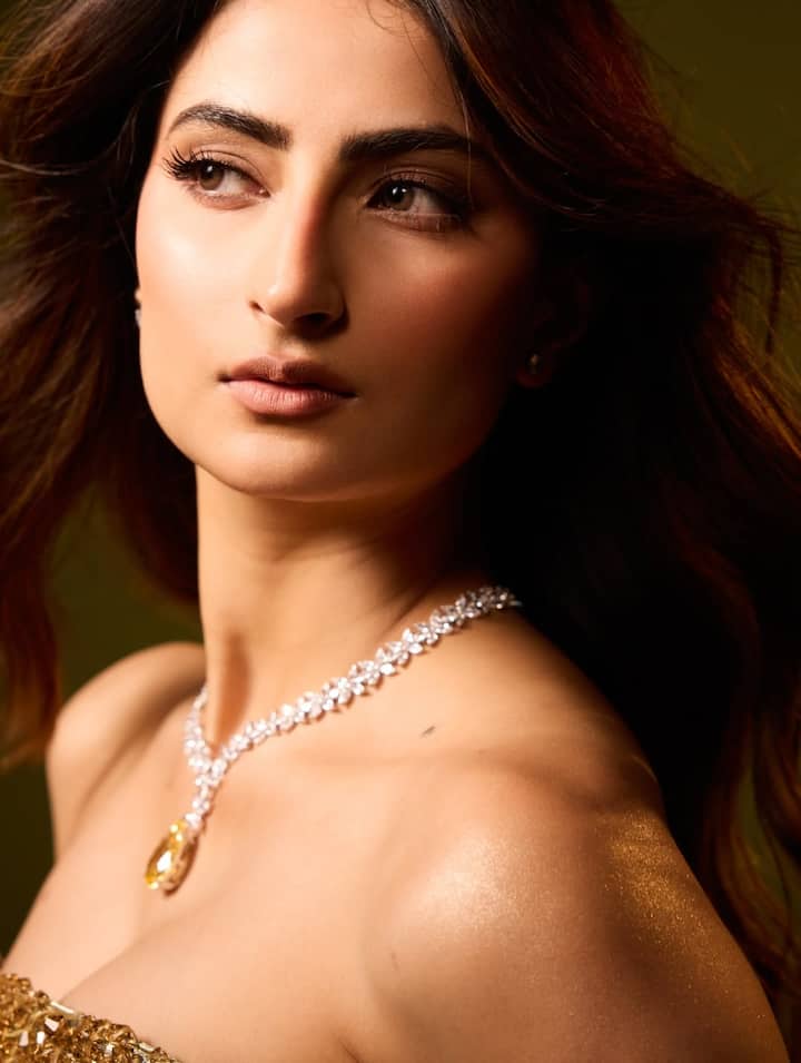 गाउन के लोअर पार्ट में इन स्टोंस को स्पेस देकर अटैच किया गया है. जहां गाउन का अपर पार्ट फिटेड है तो वहीं नीचे इस फैब्रिक को फ्लोई रखा गया है. आउटफिट को नीचे से लूज रखते हुए ट्रेल देकर इसमें ड्रामेटिक टच एड किया गया है.