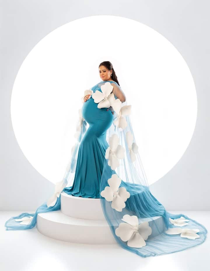 इस केप पर बड़े से व्हाइट फूल स्टिच्ड थे.भारती ने बेबी बंप पर हाथ रखकर जमकर पोज दिए. उन्होंने अपने बालों को हल्का टाई कर रखा था और मेकअप न्य़ूड था.