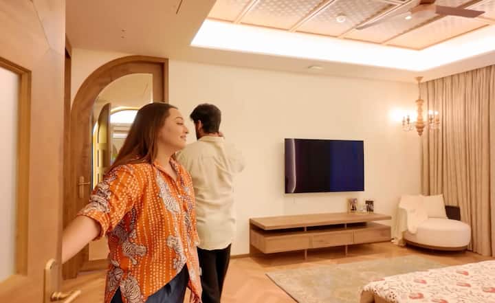 सोनाक्षी के बेडरूम में सॉफ्ट लाइटिंग और हल्के कलर का यूज किया गया है, जिससे पूरा रुम आरामदायक और ब्राइट लगता है. कमरे का डिजाइन सिंपल और क्लासी है, जिसमें मिनिमल फर्नीचर और साफ-सुथरी सजावट दिखाई देती है.