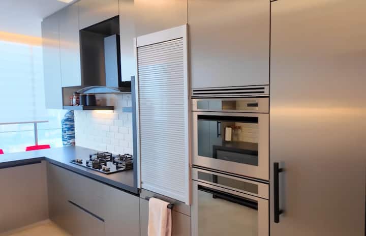 उनके घर का ओपन किचन बेहद मॉडर्न और सिंपल डिजाइन में तैयार किया गया है. ग्रे और लाइट टोन थीम के साथ इसका स्पेस काफी खुला और ब्राइट दिखाई देता है. स्मार्ट स्टोरेज, क्लीन स्लैब और मिनिमल डेकोर इसे और भी क्लासी फील देते हैं.