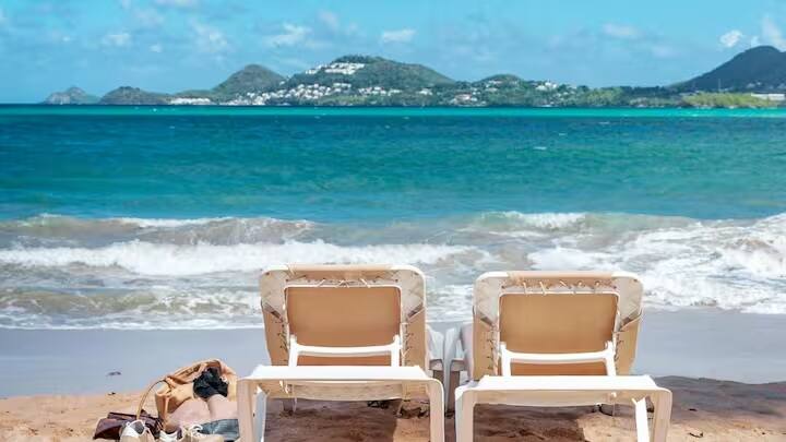 Which Country is Named After a Woman: દુનિયા સુંદર ટાપુઓથી ભરેલી છે. પરંતુ આ એકમાત્ર રાષ્ટ્ર છે જ્યાં દરેક ખૂણો એક મહિલા સંતના વારસાની કહાણી કહે છે. ચાલો જાણીએ તેના વિશે. કેરેબિયન સમુદ્રના વાદળી કિનારા પર આવેલો એક નાનો ટાપુ વિશ્વના બાકીના ભાગોથી એક અલગ ઓળખ ધરાવે છે. એક એવો દેશ જેનું નામ એક જ પ્રશ્ન ઉભો કરે છે: તેને વિશ્વનો સૌથી સ્ત્રી (ફેમિનિન) દેશ કેમ કહેવામાં આવે છે? મોજાઓના આ શાંત ટાપુનું નામ એક મહિલાના નામ પરથી કેમ રાખવામાં આવ્યું છે? આ વાર્તા ઇતિહાસમાં કંડારાયેલી છે, અને તેનું રહસ્ય એટલું રસપ્રદ છે કે તે કોઈપણનું ધ્યાન આકર્ષિત કરી શકે છે. ચાલો તેના નામ પાછળની વાર્તા જાણીએ.