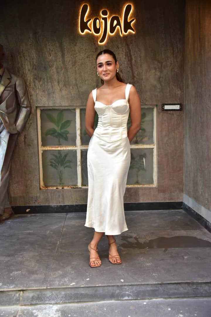 Shalini Pandey's look is giving a very soft, elegant and classy vibe. The off-white satin dress looks very graceful on her. The hair is tied in a sleek ponytail, which is making the whole look even more clean and polished.