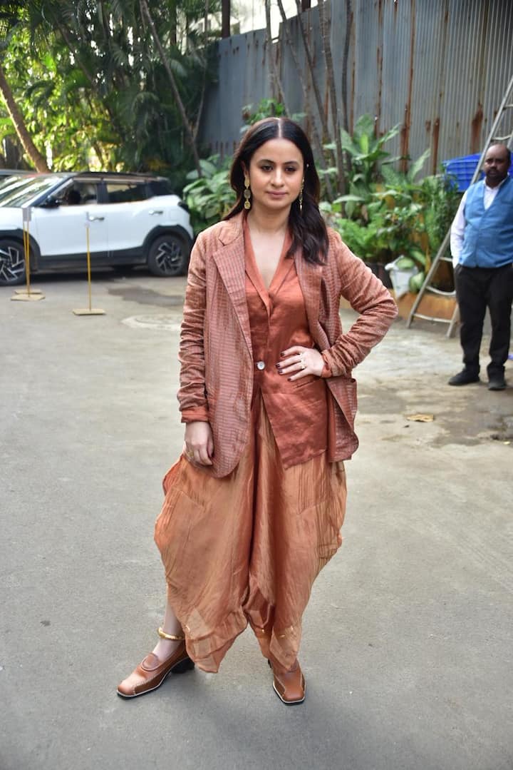 Rasika Duggal's look is giving a very boho-chic and Indo-fusion vibe. This outfit with copper and rust shades gives a warm, earthy and stylish touch to her entire look. The hair is open in soft waves, and long statement earrings give the perfect traditional-meets-modern finish to her entire look.