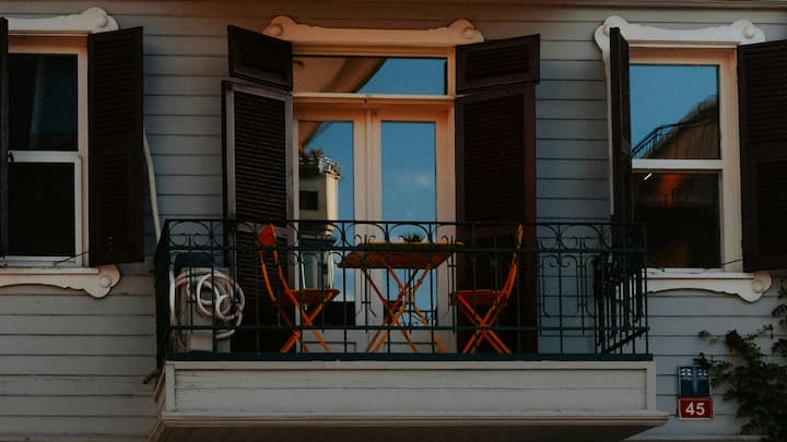 Soft Accessories and Lighting to Create an Evening Escape: Nothing sets a soft mood like good, soft, layered, warm lighting. The atmosphere can easily be set with warm lighting, such as soft fairy lights, pendants that can be layered, or solar lanterns that wash the space in a calm glow. Residents use this space to unwind with a good read or host a soft gathering under the calming glow. (Image Source: Canva)