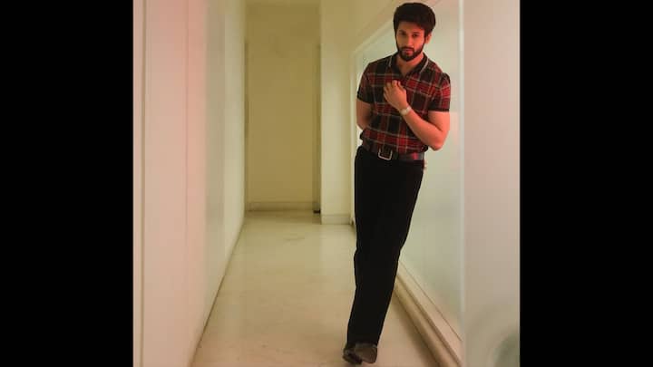 6. ⁠Casual Check Shirt Look: Rohit Saraf channels effortless charm in this classic red-and-black checkered shirt, delivering major college-day nostalgia with a modern twist. Rohit sports a short-sleeved checkered shirt in rich tones of red, black, and yellow, giving the classic print a youthful update. The fitted silhouette adds sharpness, while the relaxed styling keeps the look approachable and campus-friendly. Rohit pairs the check shirt with sleek black trousers, creating a neat monochrome base that allows the print to stand out. The tucked-in styling, paired with a belt, adds definition and gives the outfit a crisp finish. His minimal wristwatch adds a classic touch, proving that even the simplest accessories can refine a casual look. (Image Source: Instagram/@rohitsaraf)