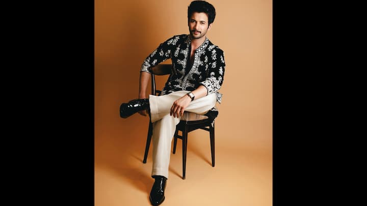 3. ⁠Black Embroidered Kurta Look: Rohit Saraf delivers one of his most striking moments in this impeccable crafted black embroidered kurta teamed with timeless ivory trousers. This look blends traditional detailing with modern tailoring. The centrepiece of this outfit is the black long line kurta, showcasing a marriage of craftsmanship and contemporary flair. The sharp neckline, structured shoulders, and ornate thread work elevate the ensemble. Balancing the richness of the kurta, Rohit pairs it with tailored ivory trousers, creating a monochrome yet high-impact palette. He finishes the look with glossy black formal shoes, adding a slick, modern finish to the traditional look. (Image Source: Instagram/@rohitsaraf)