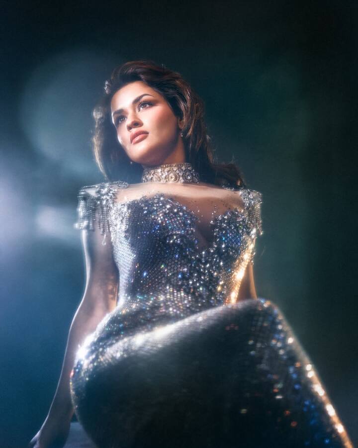 In makeup, she has kept a subtle glam look, soft base, nude brown lipstick, and a little glow which highlights naturally in the camera lights. Light shimmer and soft eyeliner on the eyes have made her expression even more striking.