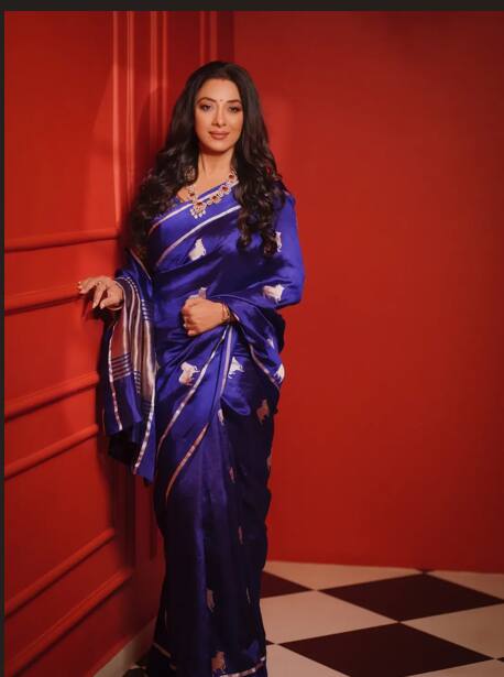 रुपाली गंगुली ने जो ब्लू सिल्क साड़ी पहनी है, उस पर बने छोटे-छोटे मोटिफ इस आउटफिट को एकदम क्लैसी और रिच वाइब देते हैं. साड़ी की शाइन और फॉल देखकर साफ लगता है कि ये एक प्रीमियम पीस है. बॉर्डर पर मेटालिक लाइन्स लुक को और भी स्टाइलिश बनाती हैं.