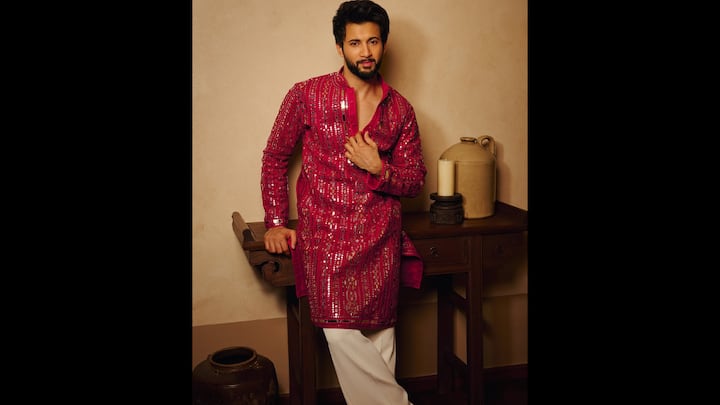 5. ⁠Mirror-Work Pink Kurta: Rohit Saraf turns up the festive glamour in this vibrant pink mirror-work kurta. The highlight of this ensemble is the rich pink kurta intricately embellished with traditional mirror work and detailed thread patterns. Rohit’s choice of a deep neckline adds a modern, youthful twist to a heritage design, making the outfit both classic and contemporary. Keeping the focus on the stunning kurta, Rohit pairs it with cream trousers that add balance without diluting the impact. The neutral bottom makes the ensemble more wearable and ensures the mirror-work detailing remains centre stage. (Image Source: Instagram/@rohitsaraf)