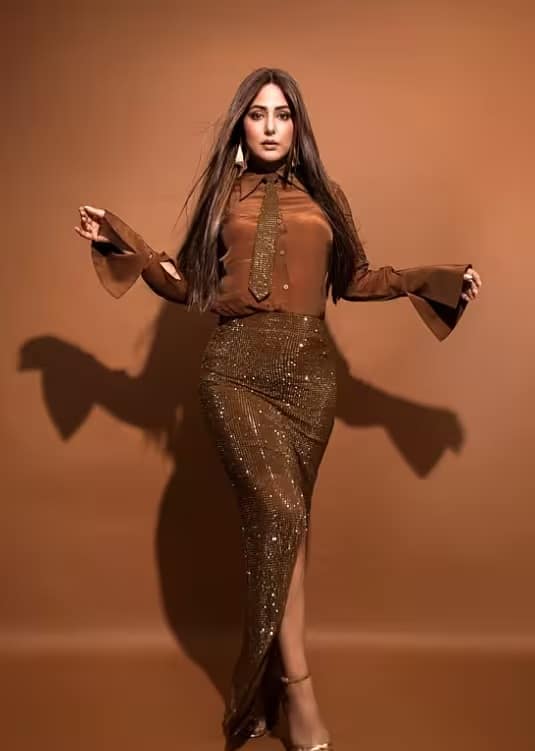 हिना खान इस गहरे भूरे रंग के मोनोक्रोम लुक में बेहद खूबसूरत लग रही हैं। सिंपल शर्ट और चमकदार फिटेड स्कर्ट का मेल इस आउटफिट को क्लासी और आकर्षक बनाता है। नए साल के जश्न के लिए इसे सीधे बालों और मिनिमल मेकअप के साथ स्टाइल करें, जिससे एक परिष्कृत और आत्मविश्वास से भरपूर लुक मिलेगा।