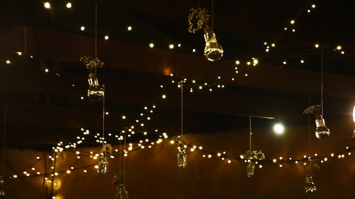 Gatherings for DIY decorations: Skip pricey home decoration items and act creatively to celebrate. Common areas are transformed into a warm holiday corner with items you create, such as fairy lights and homemade ornaments; recycled jars make a beautiful addition. DIY gatherings are not only budget-friendly but are also a form of therapy for guests and a bonding experience for travellers working together to decorate as if they are creating their own home. (Image Source: Canva)