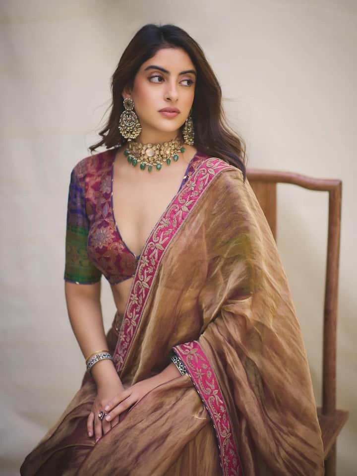 आपके लुक को और भी खास बनाने के लिए नव्या ने चोकर और हैवी इयरिंग्स पहने. साथ ही मिनिमल मेकअप और सॉफ्ट कर्ली हेयर्स रखे जिसमें वो काफी ब्यूटीफुल लगी.