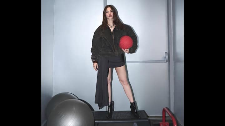 1. Bold Athleisure Chic In An Oversized Jacket: Tamannaah Bhatia once again proves why she is one of the most experimental dressers in Indian cinema with this striking athleisure-inspired outfit that blends edge, confidence, and contemporary fashion. The actor is seen wearing an oversized dark-toned jacket, styled deliberately loose to create a powerful, almost street-style silhouette. The voluminous jacket contrasts sharply with her sleek black mini outfit underneath, instantly drawing attention to the play between structure and fluidity. What truly elevates the look is the asymmetrical drape detail attached to the mini ensemble, adding movement and drama while breaking away from predictable silhouettes. The outfit strikes a perfect balance between sporty and high-fashion, further reinforced by her choice of black ankle boots that add a strong, grounded finish. Styled with minimal accessories and soft, natural makeup, Tamannaah lets the outfit speak for itself. (Image Source: Instagram/@tamannaahspeaks)