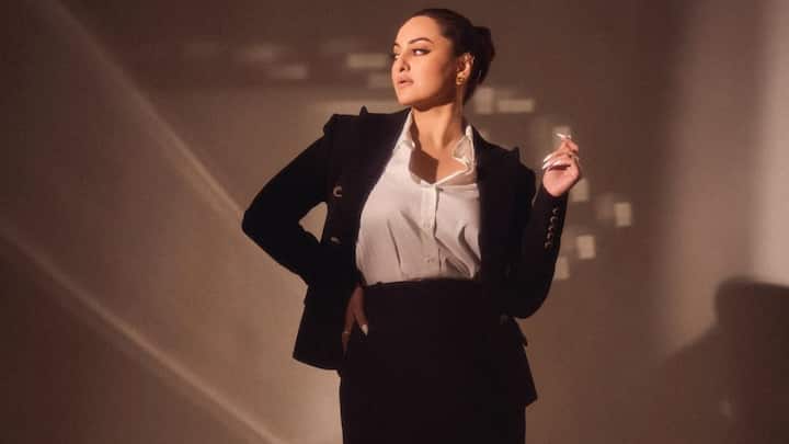 Classic Black Blazer With Editorial Drama: A sharply structured black blazer with strong shoulders defines this timeless look. Styled with a crisp white shirt and a floor-length skirt, Sonakshi turns classic suiting into a cinematic power statement. (Image Source: Instagram/ aslisona)