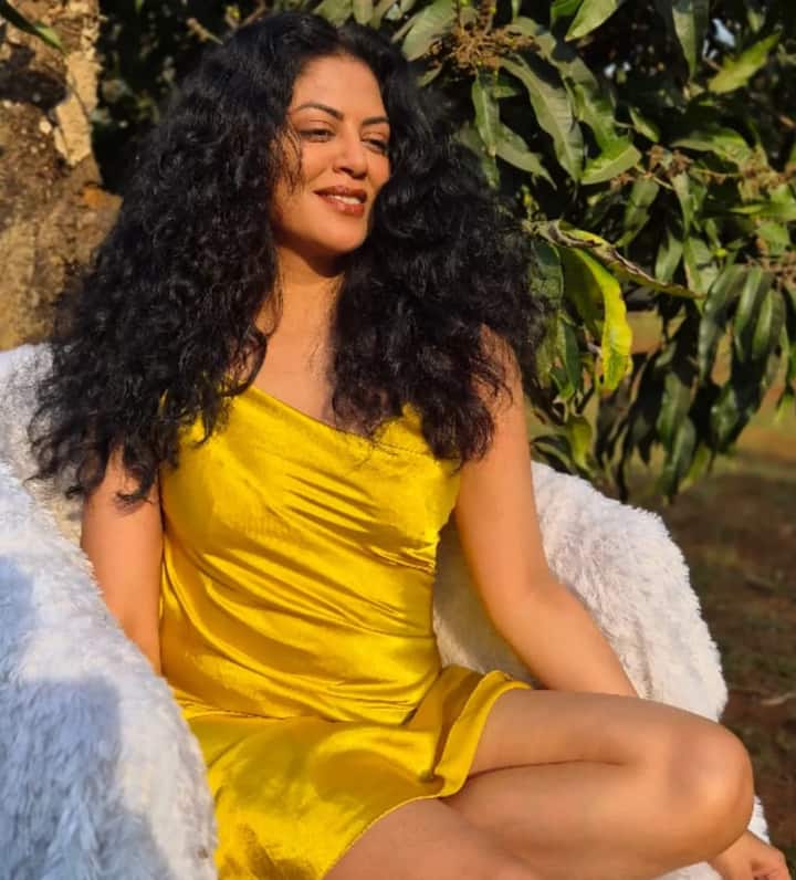 In this picture, Kavita Kaushik is wearing a bright yellow one-shoulder dress, which is making her entire look fresh and attractive. This outfit is giving her a modern and confident look.