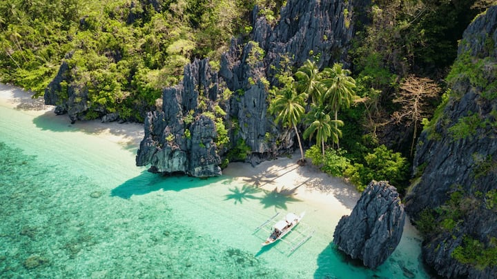 Entalula Beach, El Nido, Philippines: Tucked away among towering limestone cliffs, Entalula Beach feels like a slice of untouched paradise. Its powdery white sand and crystal-clear turquoise waters create a serene setting, perfect for swimming and snorkeling in peace. (Image Source: x/ DyprPalawan)