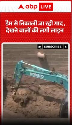 बांध से गाद हटाई जा रही है, इसे देखने के लिए लोगों की भीड़ जमा हो गई है।