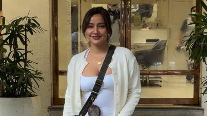 Neha Sharma spotted in Bandra wearing a white tank top paired with light-wash, distressed balloon-fit jeans.