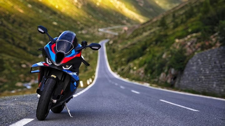 आपको बता दें कि, बीएमडब्ल्यू M 1000 RR का नाम सुनते ही हर रेसिंग लवर के दिल की धड़कनें तेज हो जाती हैं. करीब 49 लाख रुपये की कीमत में मिलने वाली यह सुपरबाइक पूरी तरह से कार्बन फाइबर बॉडी और एडवांस एयरोडायनामिक्स के साथ तैयार की गई है. इसका स्पोर्टी लुक और रॉ पावर ऑन-रोड हर किसी को अपनी तरफ खींचने के लिए काफी है.