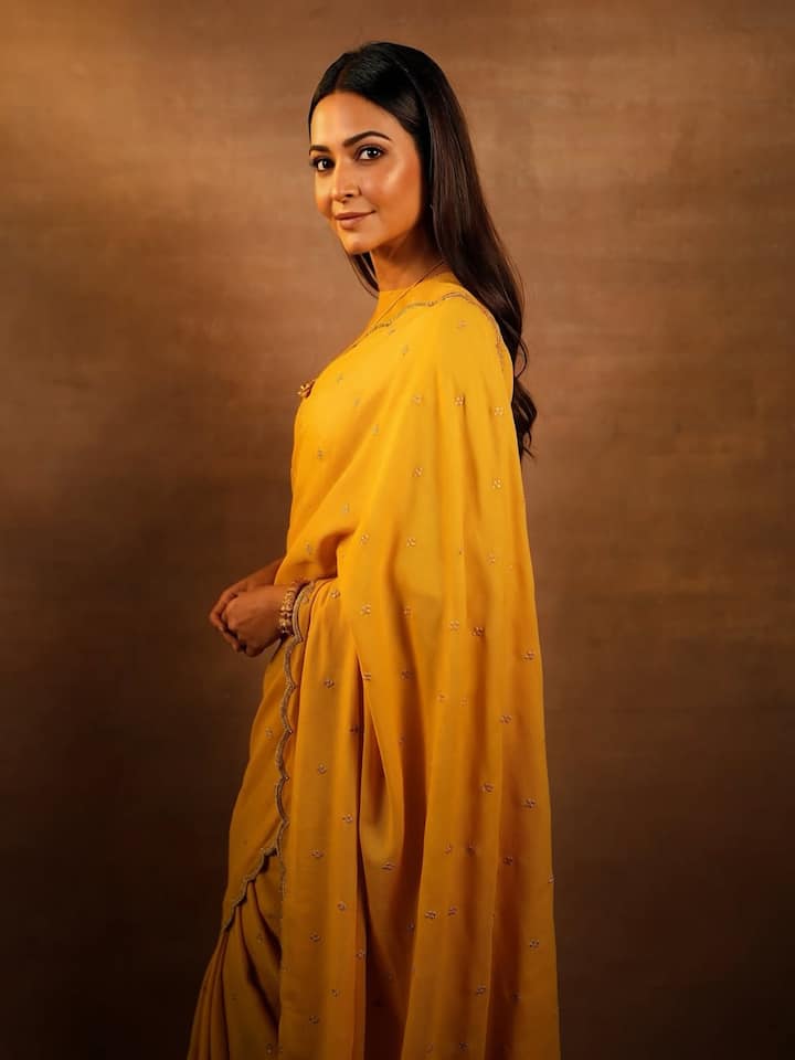 मस्टर्ड येलो साड़ी में कृति का सादगी भरा और खूबसूरत अंदाज नजर आ रहा है. बारीक कढ़ाई, स्कैलप्ड बॉर्डर और मिनिमल स्टाइलिंग ने उनके पूरे लुक को बेहद आकर्षक बना दिया.